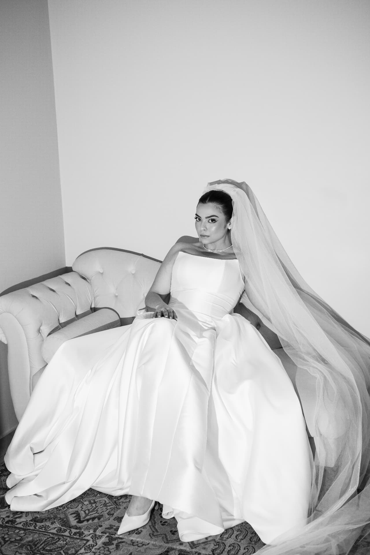 Noiva sentada com vestido e véu em retrato preto e branco